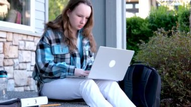 Kız, internetten hocasıyla internetten kulaklıklı dizüstü bilgisayardan öğreniyor. Çalışmak için bir arkadaşıyla konuşan kadınların portresi. Evde online öğrenim kavramı. Yüksek kalite