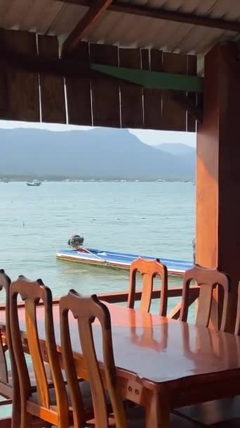 서있는 지붕이있는 호수에 지어진 물고기 농장의 움직이는 보트에서보기 배경에 화산을 — 비디오