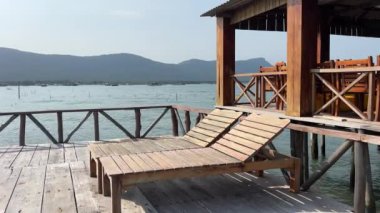 Tahta sandalyeli ahşap iskele, Güney Doğu Asya manzaralı.