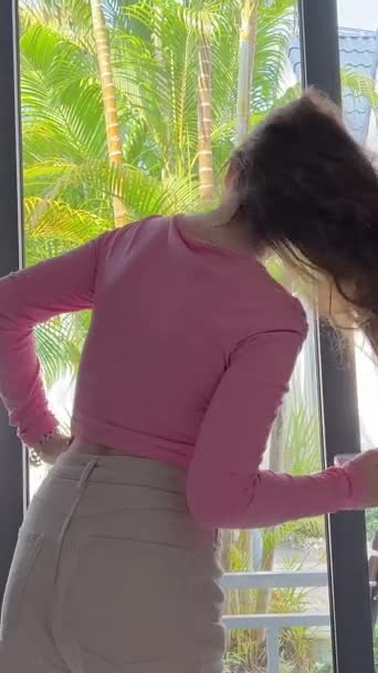 Pige Med Telefon Ved Vinduet Tropiske Land Pink Sweater Shorts – Stock-video
