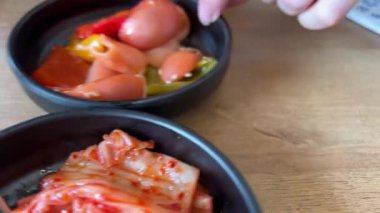 Kore restoranında kimchi lahanası, Kore 'den ünlü mayalanmış yemekler. Genç bir kız restoranda kimchi yiyor..