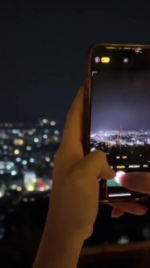 Genç, mutlu kadın cep telefonuyla fotoğraf çekiyor. 