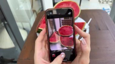  Vejetaryen kadın sağlıklı antioksidan renkli sebzelerin fotoğrafını çekiyor. Buzdolabındaki karpuz pazarından sonra yemek için çiğ meyve suyu. akıllı telefondan