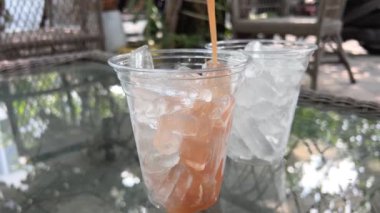 Bir şişe guava suyu, guava dilimleri ve beyaz masada guava meyvesi.