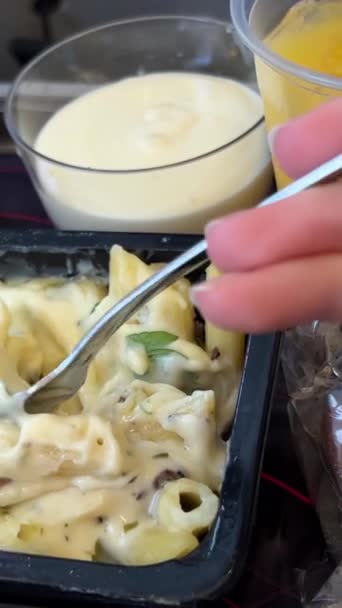 一名妇女的特写镜头是用飞机上的塑料容器里的肉吃意大利面 在商业飞机上吃饭的女人 人们在飞机上吃饭 乘客在飞行期间享用热饭 — 图库视频影像