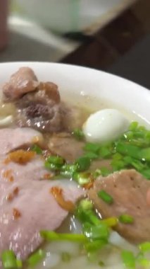 Pho Tavuklu erişteli flüt sağlıklı besin sebzeli ve ahşap tahtada baharatlı. Tavuktan arta kalan yemekleri sağlıklı beslenme konsepti. Erişteli erişte çorbası. Çorbalı karabiber.