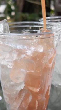 Bir şişe guava suyu, guava dilimleri ve beyaz masada guava meyvesi.