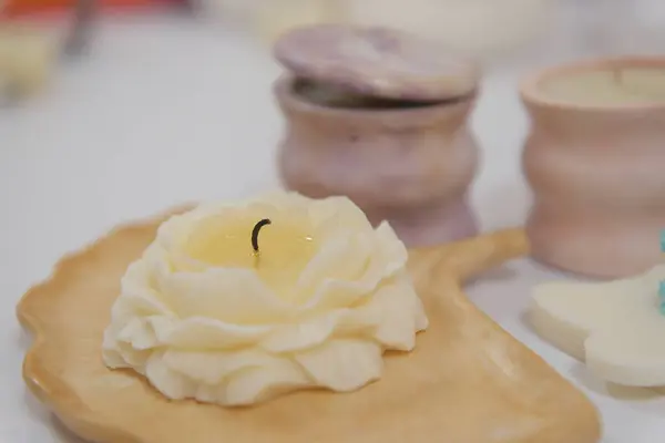 woman making candles at home, close up of female hands pouring yellow liquid wax from pan into silicon mold. High quality cut off vetil candle make aroma candles