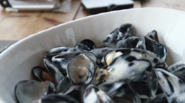 Beyaz bir tabakta kabuklu pişmiş midye yakın çekim. Panorama. Yüksek kalite 4k