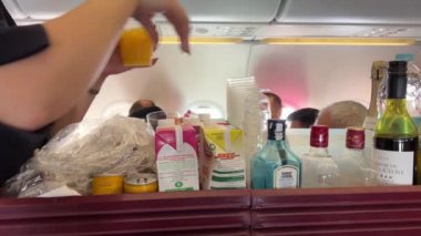 Hostes yemeği Doha Hamad Katar Havayolları Katarı 'nı içiyor. Doha Havaalanı 10.04.2024