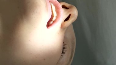 Diş hekimliği ergenliği, sarı eldivenli bir doktor dişçide dişçiye yakın çekim videosu için genç bir kızın dişini doldurur ve dişini yeni teknolojilerle kurutur. modern klinik