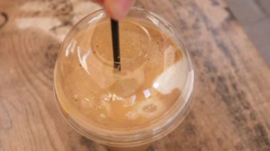 Güzel Avrupalı kız buzlu latte içiyor. Genç İspanyol kadın güneşli restoran terasında buzla bardağa kahve dolduruyor.