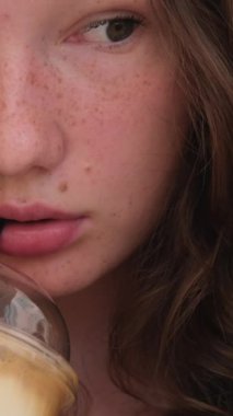 Güzel Avrupalı kız buzlu latte içiyor. Genç İspanyol kadın güneşli restoran terasında buzla bardağa kahve dolduruyor.