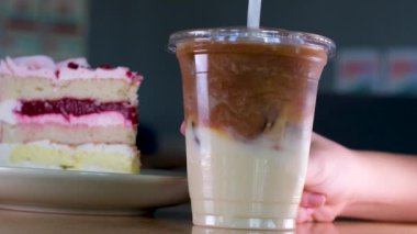 Plastik bardakta buzlu latte ve vişneli turta. 