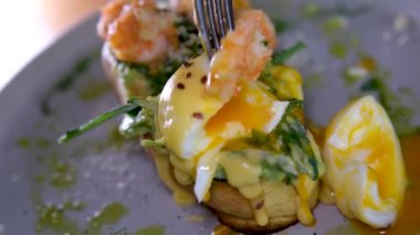 Avokado, yumurta, keten tohumu, ayçiçeği, balkabağı, domates ve sebzeli tam tahıllı sandviç. Ekmeğin tamamı. Benedict yumurtaları ve karides.