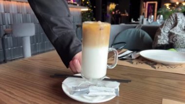 Garson iki latte servis ediyor, sıcak ve soğuk, iki aromalı, buzlu latte ve sıcak geç kalmış.
