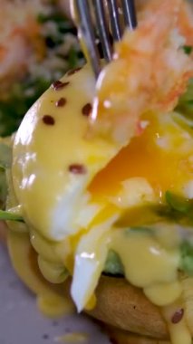 Avokado, yumurta, keten tohumu, ayçiçeği, balkabağı, domates ve sebzeli tam tahıllı sandviç. Ekmeğin tamamı. Benedict yumurtaları ve karides.