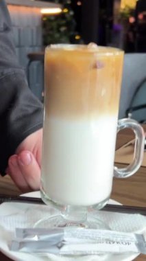 Garson iki latte servis ediyor, sıcak ve soğuk, iki aromalı, buzlu latte ve sıcak geç kalmış.