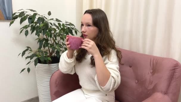 Розслаблена Молода Жінка Насолоджується Чашкою Кави Своїй Світлій Вітальні — стокове відео