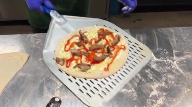 Fırıncı pizzayı fırına bir fırıncı spatulasının yardımıyla koyar. Fırında pizza pişirme süreci. Lezzetli pizza pişirme kavramı. Adım adım. Adım 8. Orta atış. Yavaş çekim