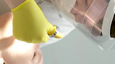 Diş hekimliği ergenliği, sarı eldivenli bir doktor dişçide dişçiye yakın çekim videosu için genç bir kızın dişini doldurur ve dişini yeni teknolojilerle kurutur. modern klinik