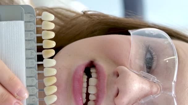 牙齿美白 完美的白冠牙齿与阴影导引漂白的颜色紧密相连 女性面膜微笑 牙科护理和口腔科 牙科学 版权空间 — 图库视频影像
