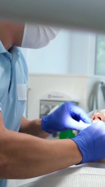 Erkek dişçi klinikte dişlerini tedavi ediyor. Yüksek kalite 4k görüntü