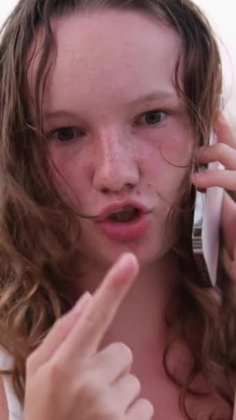 一个女人在电话上交谈 命令送货 与朋友交流 使用社交网络和互联网 在海滩上放松年轻女孩烧焦的皮肤 湿发的感情 — 图库视频影像