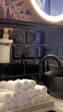 Lüks jakuzi banyosu, bir otelde musluğun yanına istiflenmiş havlular, kaygan çekimler. Havlular Oteli.