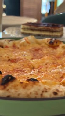Lezzetli elastik peynirli bir dilim taze pişmiş pizza aldım. Siyah arka planda fırında pişirilmiş lezzetli İtalyan pizzası.