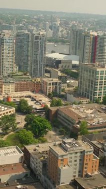 Şehir merkezindeki insanlar gerçek zamanlı olarak evleri çekiyor. Gökdelenler ve Pasifik Okyanusu. Kanada Vancouver 05.12.2024