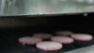 Buzlu hamburger köftelerini ızgaraya koymak için yakın plan. Evde yemek pişirme, mutfak aletleri, sağlıklı beslenme, hamburger malzemeleri.
