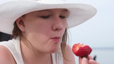 Woman eats strawberries. Mouth close-up. A woman eats strawberries 