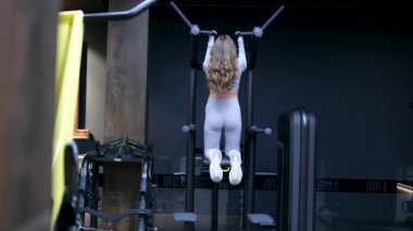 Woman doing pull-up. Strong girl in sportswear doing pull up exercise. H3althy