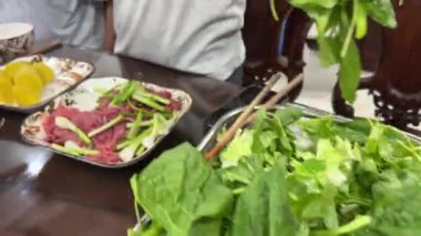 Vietnamese food shells mussels rapan fish cooking Vietnamese soup with green leaves and pieces. Cooking soup with herbs in a restaurant