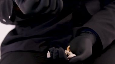 In black gloves, sprinkle human teeth into your hand. Knock out all your teeth. Teeth on the hands of a doctor