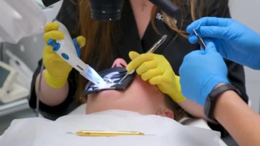 At the dental clinic a dentist examines a patient with toothache under microscope. Dental treatment under a microscope dentistry