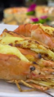Otlu ızgara ıstakoz menüsü ve akşam yemeği tabağında fırında peynir. Taze deniz ürünleri menüsü olan lüks bir restoran. Krem ve peynirle doldurulmuş taze ızgara ıstakoz yemek.. 