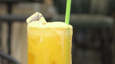 Dispenser for lemonade and drinks Pouring Fresh Orange Juice into Glass with Ice