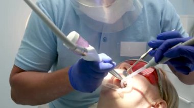 Doctor scans the patients teeth in the clinic. The dentist holds in his hand a manual 3D scanner for the jaw and mouth. Dental health. Creates teeth and gums on medical monitor.