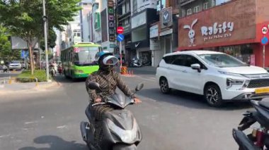 Motosikletli taksi şoförü Avrupalı genç kadını alıp Vietnam 'da bir yolculuğa çıkarıyor. 05.23.2024 Ho Chi Minh Şehri' nde. 