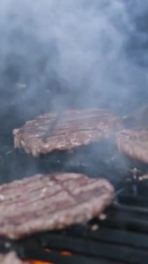 Tasty meat for a burger cooked on a fiery barbecue grill. Close up of chief cooked oil unhealthy, but very satisfying protein tasty burger in casual bar. cooking beefsteak on the grill barbecue