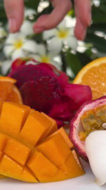 Dragon fruit Citrus fruits, sliced decoratively, on a black wooden table. Lemon, lime, orange, blood orange, mandarin. 