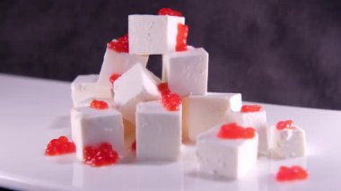 Kırmızı havyar peyniri parçalara ayrıldı. Yunan salatası hazırlığı. Dilimleme feta