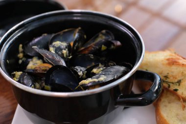 Midye ve istiridye pişirme süreci. Geleneksel deniz ürünlü makarna malzemeleri. Mutfakta kova pişiriyorum. Kızartma tavası ve haşlanmış midye. Modern mutfak ve mutfak aletleri. Soslu midyeler.