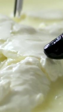 Mutfakta, koruyucu saç şapkasının önünde peynir hazırlayan bir kadın. Peyniri saf ineklerin sevgisiyle hazırla süt ve keçilerin sütüyle.