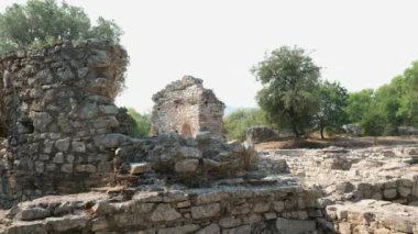 Arnavutluk 'taki Butrint veya Butrinto Ulusal Parkı arkeolojik kalıntılarında Büyük Bazilika' yı ziyaret eden bir turist. 