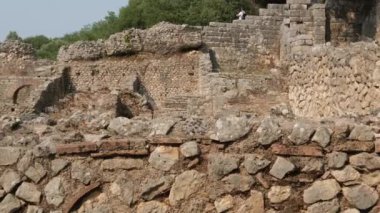 Arnavutluk 'taki Butrint veya Butrinto Ulusal Parkı arkeolojik kalıntılarında Büyük Bazilika' yı ziyaret eden bir turist. 