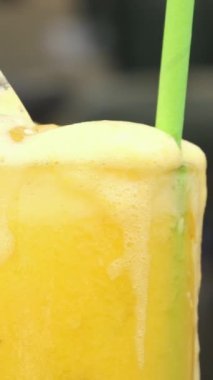 Dispenser for lemonade and drinks Pouring Fresh Orange Juice into Glass with Ice