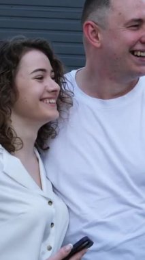 Utanç verici haberleşme adamı ve kadın duvarın yanında durur. Sarılan kız gözlerini indirir kıvırcık saçlı genç kız. Şirketteki çift erkek ve kadın.